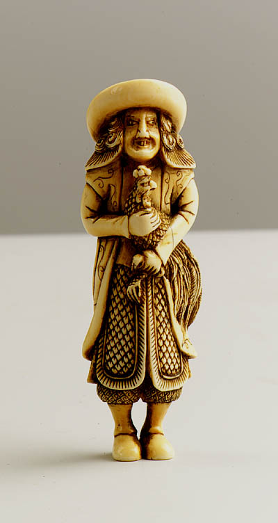 4914/501:Deshima Ivory netsuke of a standing Dutchman holding a cock.